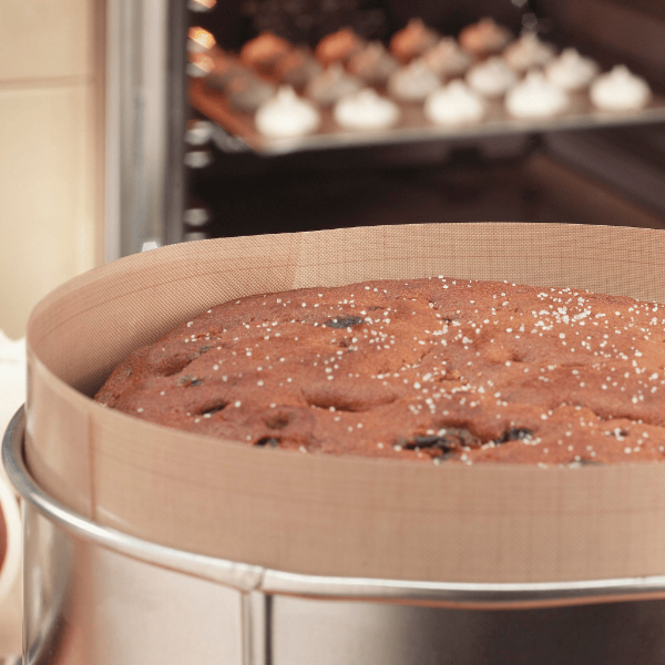 Fruit cake baked in a round tin lined with a non-stick Bake-O-Glide® liner, with a tray of bakes in the oven behind