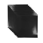 Ten black non stick reusable baking sheets on a white background