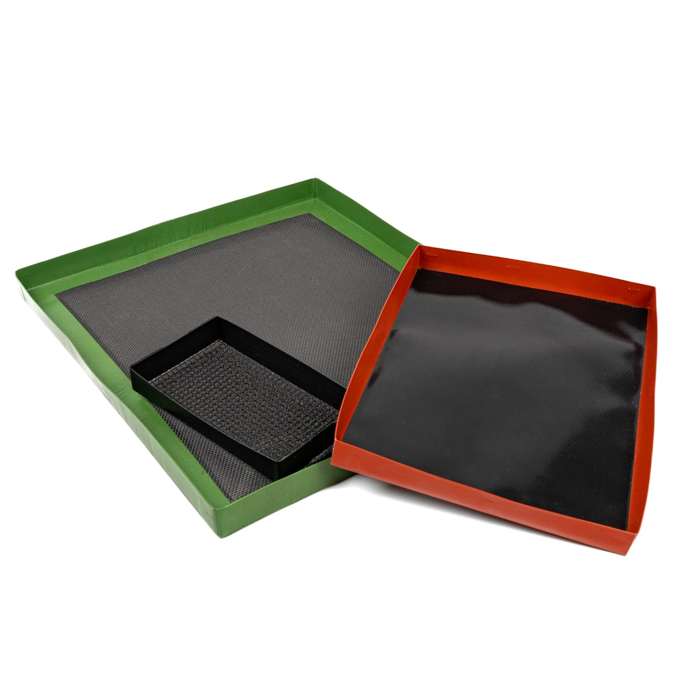 Two square high speed oven trays shown open on a white background, one with a green border and one with a red border, both containing black textured material.